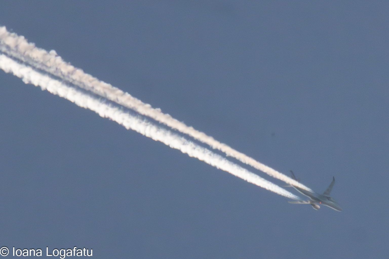 High-flying jet leaves trails in the blue sky